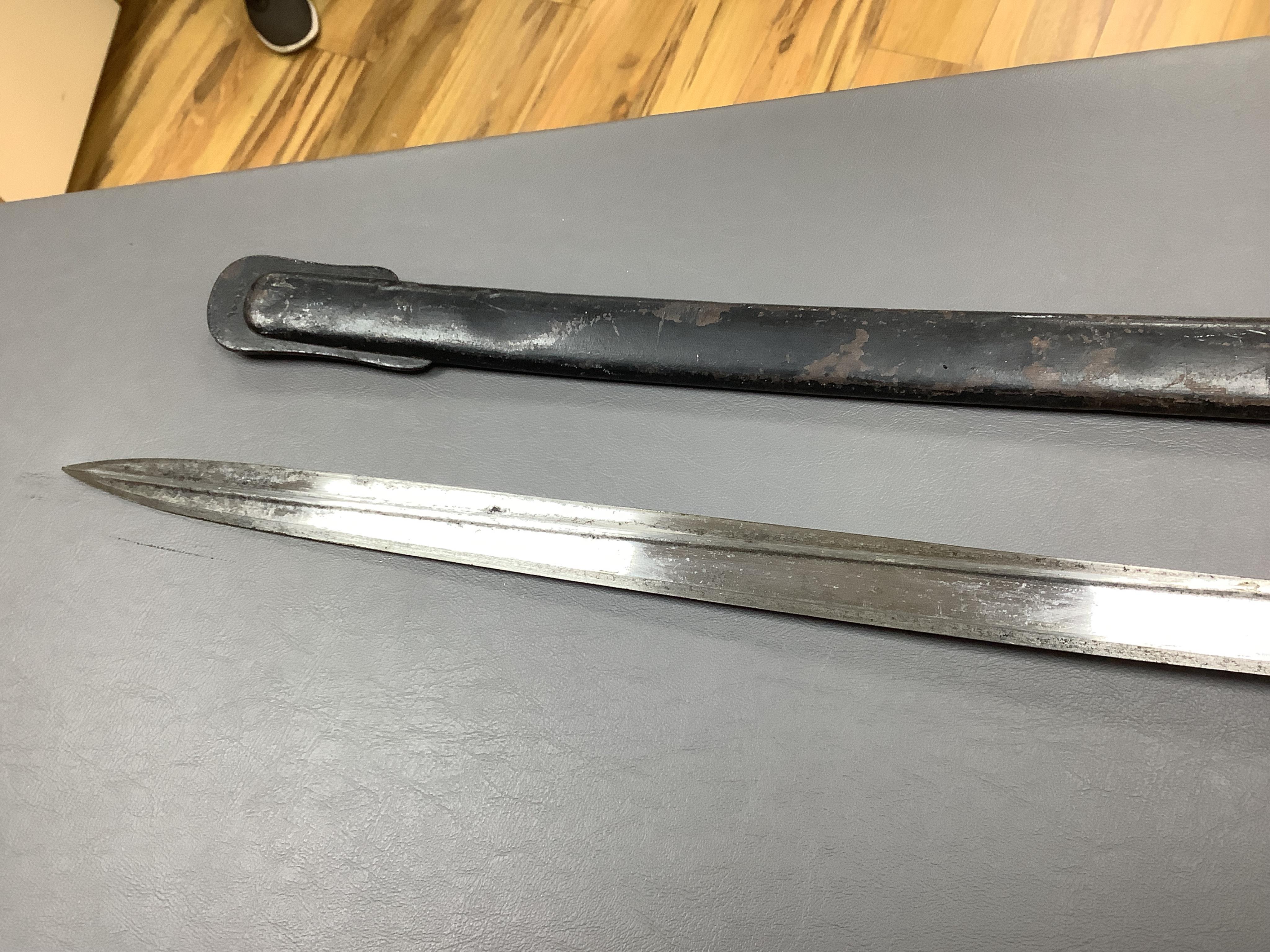 A First World War Turkish army officer’s sword, with pipe back blade, regulation iron guard pierced with crescent and moon, chequered horn grips, in its iron scabbard, together with an unidentified bayonet in its scabbar